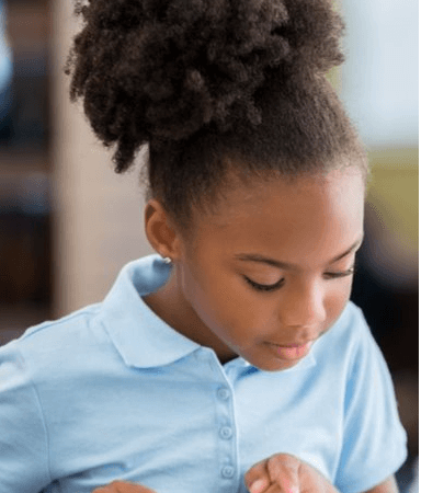 Young girl reading a book at a desk